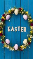 Ostern Dekoration Rahmen mit Blumen, Eier auf Blau hölzern Bretter Vertikale Handy, Mobiltelefon Hintergrund foto