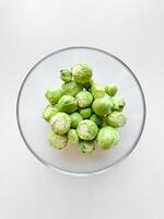 Schüssel von roh Brüssel Sprossen auf Weiß Oberfläche. frisch Grün Gemüse, gesund Essen, Vegetarier Essen Konzept mit Kopieren Raum. foto