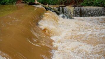 es sieht aus schließen zu das Umleitung von trübe Wasser Das fließt schnell darüber hinaus das Grenze Damm. foto