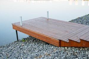 Boot Dock, hölzern Seebrücke Stehen auf das Banken von das Fluss, Stadt Teich, Plattform von Bretter auf Stelzen, ruhig Ort, Plattform zum Meditation und Yoga trainieren foto