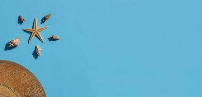 eben legen Banner. Stroh Hut, Meer Muscheln und Seestern auf Blau Hintergrund. Sommer- Konzept. oben Sicht, Kopieren Raum. Yachthafen Stil Komposition. foto