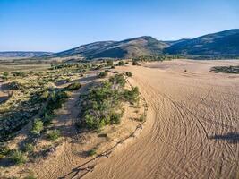 Fußabdrücke und Fahrzeug Spuren auf Sand foto