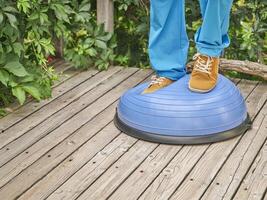 männlich Füße und Beine balancieren auf bosu Hälfte Ball foto