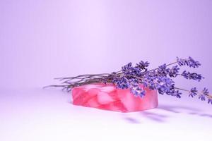 handgemachte Seife mit dem Duft von Lavendelblüten auf zartem lila Hintergrund. foto