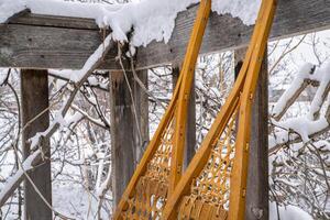 Detail von klassisch Hure Schneeschuhe auf ein hölzern Deck foto