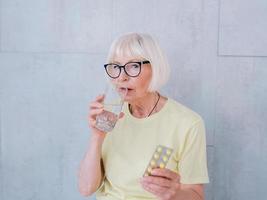 ältere Frau mit Glas Wasser und Trinkwasser. gesunder Lebensstil, Sport, Anti-Age-Konzept