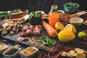 Gesunde Lebensmittelkräutergewürze zur Verwendung als Kochzutaten auf Holzhintergrund mit frischem Bio-Gemüse auf Holz. Das Konzept der Lebensmittelzutaten mit Abwechslung auf dem rustikalen Tisch. foto