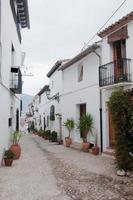 leere Straße bei Altea. schöne mediterrane Stadt mit weißen Häusern und Tontöpfen entlang der Straße. Spanien foto