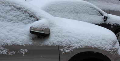 Autos bedeckt mit ein Schnee im ein Reihe nach Schneefall detailliert Lager Foto