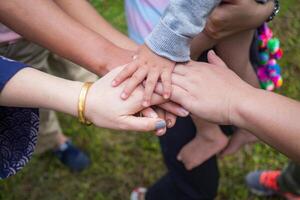 Nahansicht oben Aussicht von Hände Frauen und Kind Putten ihre zusammen. Familie mit ein Stapel von Hände zeigen Einheit und Zusammenarbeit foto