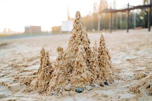 spielen mit Sand auf das Strand, Gebäude ein Schloss aus von nass Sand, Nein Menschen auf das Strand, Sonnenlicht Blendung. foto