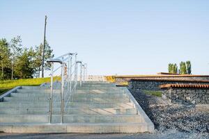 das Stadt Park Treppe steigt an hoch, das Schritte sind gemacht von Marmor, Handläufe, Geländer gemacht von Metall scheinen im das Sonne. foto