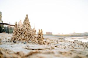 Sand Schloss im das Strahlen von Sonnenlicht, das Meer Küste innerhalb das Stadt, das Dämmerung auf das Strand, das Schloss von Sand. foto