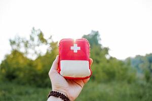 ein rot zuerst Hilfe Kit im das Strahlen von das Rahmen Sonne, Blendung von Licht scheinen durch ein rot Tasche, ein zuerst Hilfe Bausatz, Medikamente im ein Reise Tasche. foto