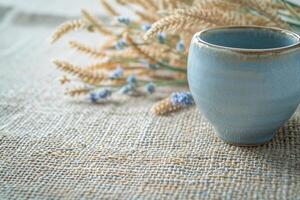 handgemacht Keramik Tasse auf ein texturiert Leinen- Tischset foto