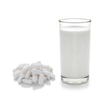 Pille und Glas Milch auf weißem Hintergrund