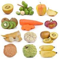 Kiwi, Macadamia, Nüsse, Trauben, Äpfel, Karotten, Spargel, Knoblauch, Zitrone, Kokospudding, Banane auf weißem Hintergrund foto