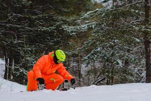 Snowboarder überprüft seine Ausrüstung foto