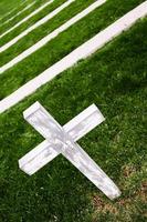 weißes Kreuz auf einem alten Friedhof foto