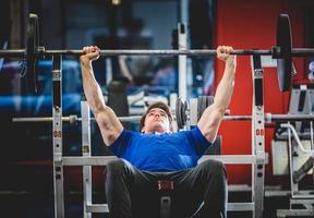 Mann macht Bankdrücken im Fitnessstudio foto