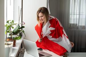 Frau Hände und Flagge von Kanada auf Computer, Laptop Tastatur foto