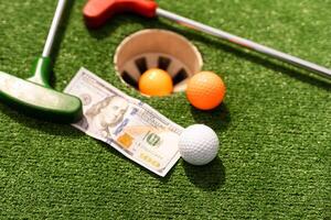 Geld, Mini Golf Bälle auf Gras. Konzept von Sport Wette foto