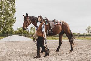 süß Chinesisch Cowgirl während nehmen Pflege von ihr Pferd foto