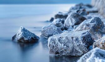 Nahansicht von frostbedeckt Felsen entlang das Kante von ein gefroren See foto