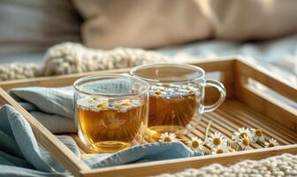 Kamille Tee einstellen auf ein hölzern Tablett foto