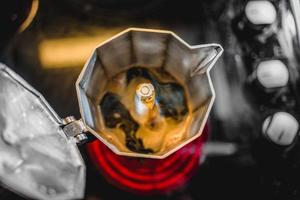 Italienische Aluminium-Kaffeemaschine, die einen frischen dunklen Kaffee auf dem Herd brüht