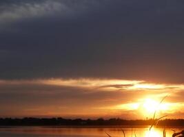 Orange beim Sonnenuntergang, schön mit Wolken foto