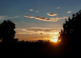 spektakulär Sonnenuntergang über, Orange Sonne steigend oben Über das Horizont foto