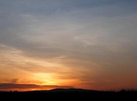 Orange beim Sonnenuntergang, schön mit Wolken foto