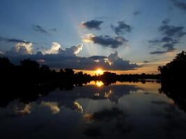 spektakulär Sonnenuntergang über, Orange Sonne steigend oben Über das Horizont foto