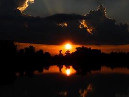 spektakulär Sonnenuntergang über, Orange Sonne steigend oben Über das Horizont foto