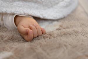 ein richtig Hand von Schlafen asiatisch Baby auf das Teppich foto