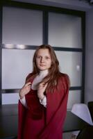 Porträt von ein jung Frau im ein rot Büro passen foto