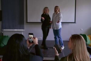 zwei Mitte Alter Frauen im Geschäft Anzüge auf Bühne im das Büro foto