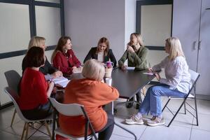 ein Mannschaft von Sieben Frauen ist halten ein Treffen im das Büro foto