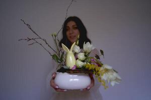 weiblich Florist machen Dekorationen und Blumen- Vereinbarungen zum Ostern foto