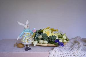 Blumen und ein Hase Lüge auf ein hölzern Stand von ein Florist auf ein Tabelle bis um Sie sind gemacht in ein Blume Anordnung zum Ostern foto