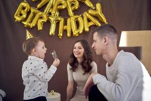 emotional Mama Uhren wie ihr Kleinkind Einspeisungen Papa Geburtstag Kuchen foto