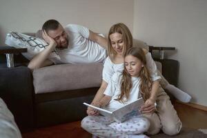 Eltern lesen ein Buch mit Tochter foto