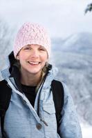 glückliches Frauenporträt auf der Spitze eines Berges im Winter foto