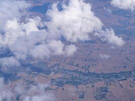 Luftbild von Land und Wolken durch Flugzeugfenster gesehen foto