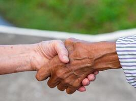 Nahansicht Bild von zittern Hände zwischen Alten Frauen. Einheit Konzept foto