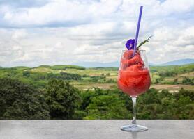 frisch gesund Wassermelone Smoothie im das Glas gegen das Hintergrund von Himmel, Wolken, und Berge. gesund Ernährung und Vitamine foto