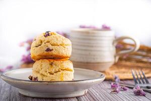 Nahansicht von traditionell britisch Scones auf ein Teller mit ein Tee Tasse und Blume verschwommen Hintergrund. Raum zum Text foto