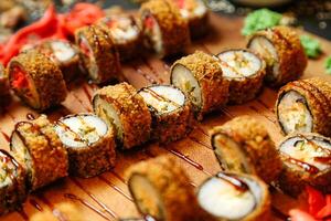 frisch Sushi Rollen auf hölzern Schneiden Tafel foto