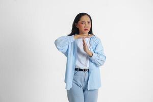 asiatisch Frau tragen beiläufig Blau Hemd tun Zeit aus Geste mit Hände und ernst Gesicht, isoliert Weiß Hintergrund foto